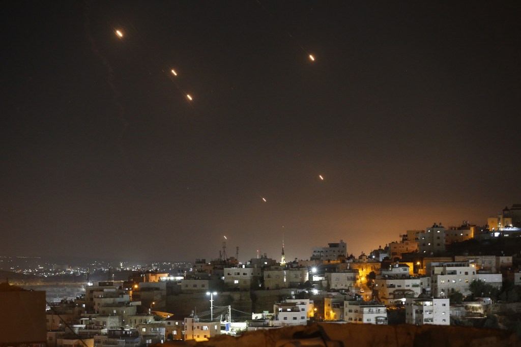 Rockets fired from Iran visible over the night lights of Jerusalem, as seen from Hebron, West Bank on Oct. 1, 2024.